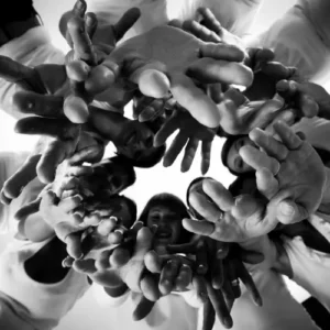 Des équipes en cercle avec des mains jointes pour une transformation en collectif par un coaching Be You Soon